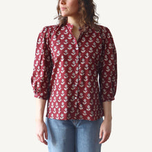 Load image into Gallery viewer, Person wearing a red floral blouse with blue jeans on a white background