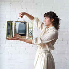 Load image into Gallery viewer, Woman holding a decorative mirror against a white brick wall