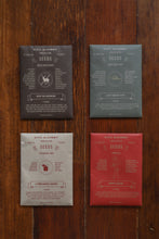 Load image into Gallery viewer, Four seed packets from Civil Alchemy on a wooden surface