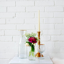Load image into Gallery viewer, Decorative items including a clear vase with flowers, a gold candlestick, and a glass bowl against a white brick wall.