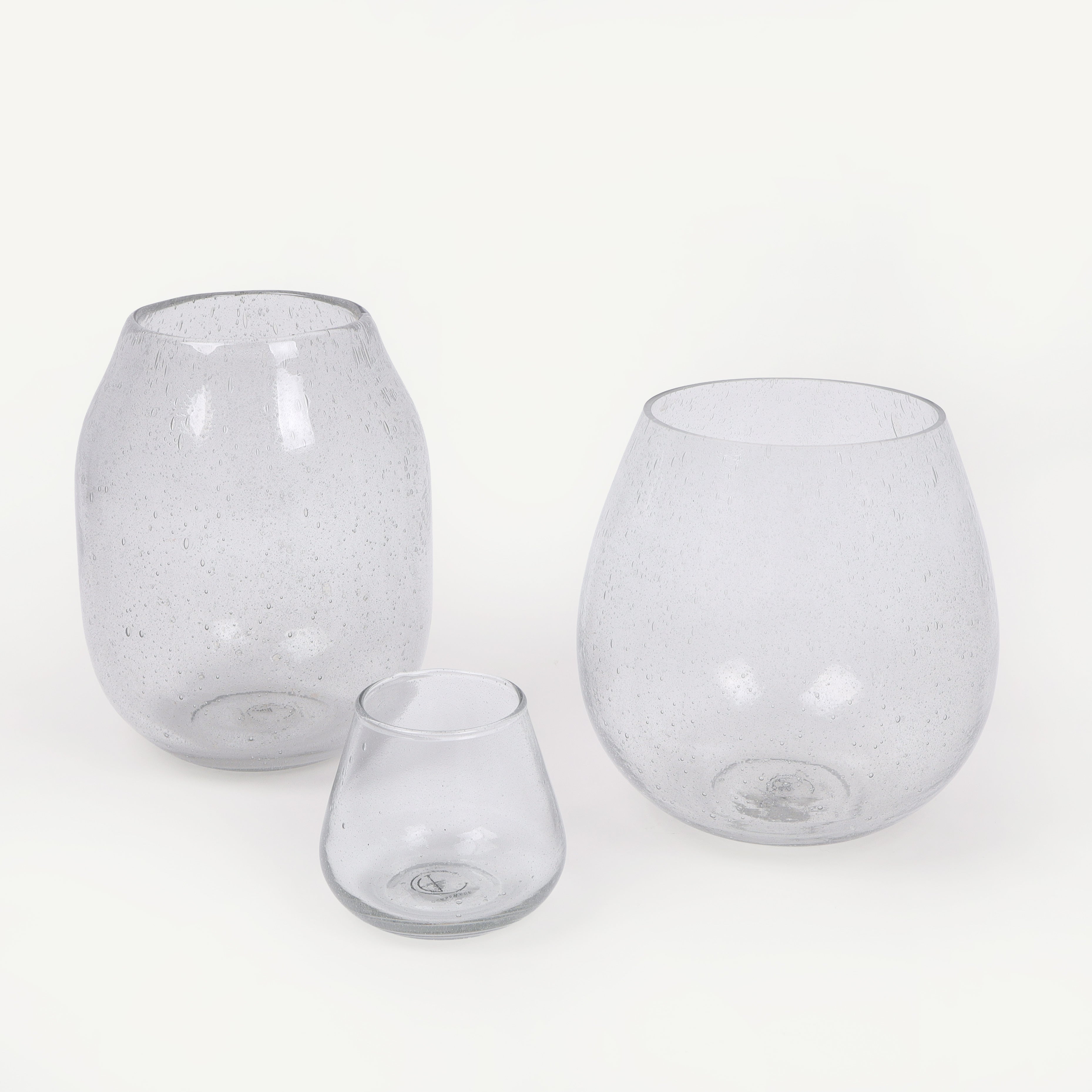 Three clear glass vases of different sizes on a white background