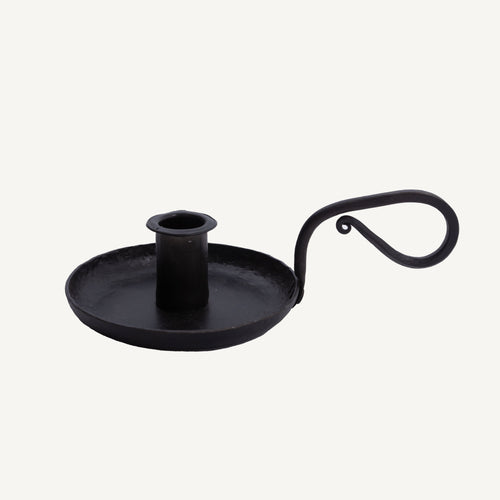 A black iron candle holder with a handle, isolated on a white background.