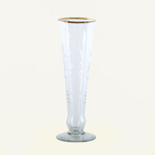 Clear glass flute with gold rim on a white background