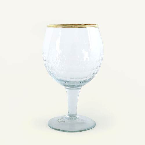 Clear glass goblet with gold rim on a white background