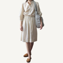 Load image into Gallery viewer, Person wearing a beige blouse and skirt with a striped bag on a plain background
