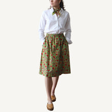 Load image into Gallery viewer, Person wearing a white shirt and green skirt with red pattern on a white background
