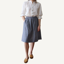 Load image into Gallery viewer, Person wearing a white shirt and blue skirt on a plain background
