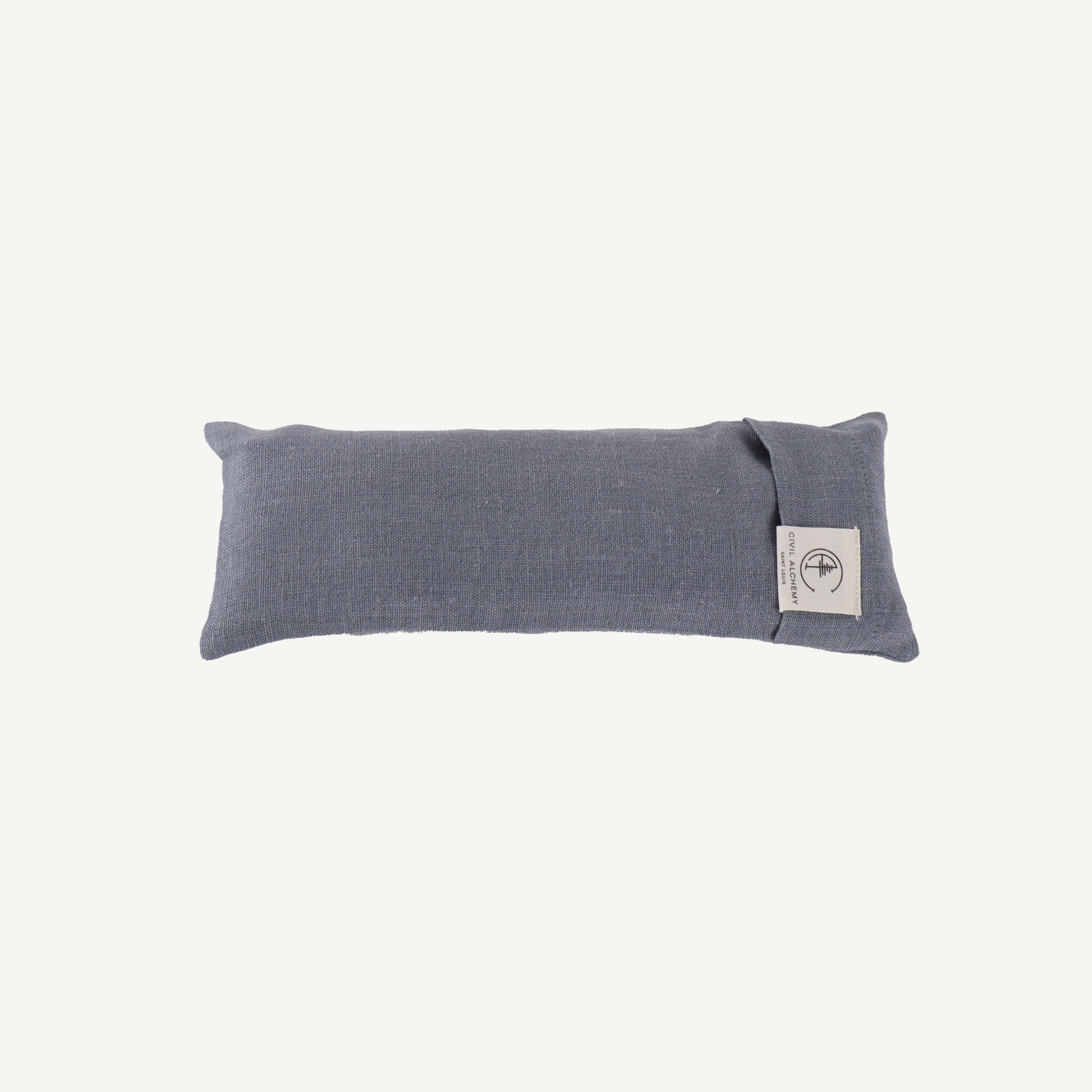 Blue fabric eye pillow with a label on a white background