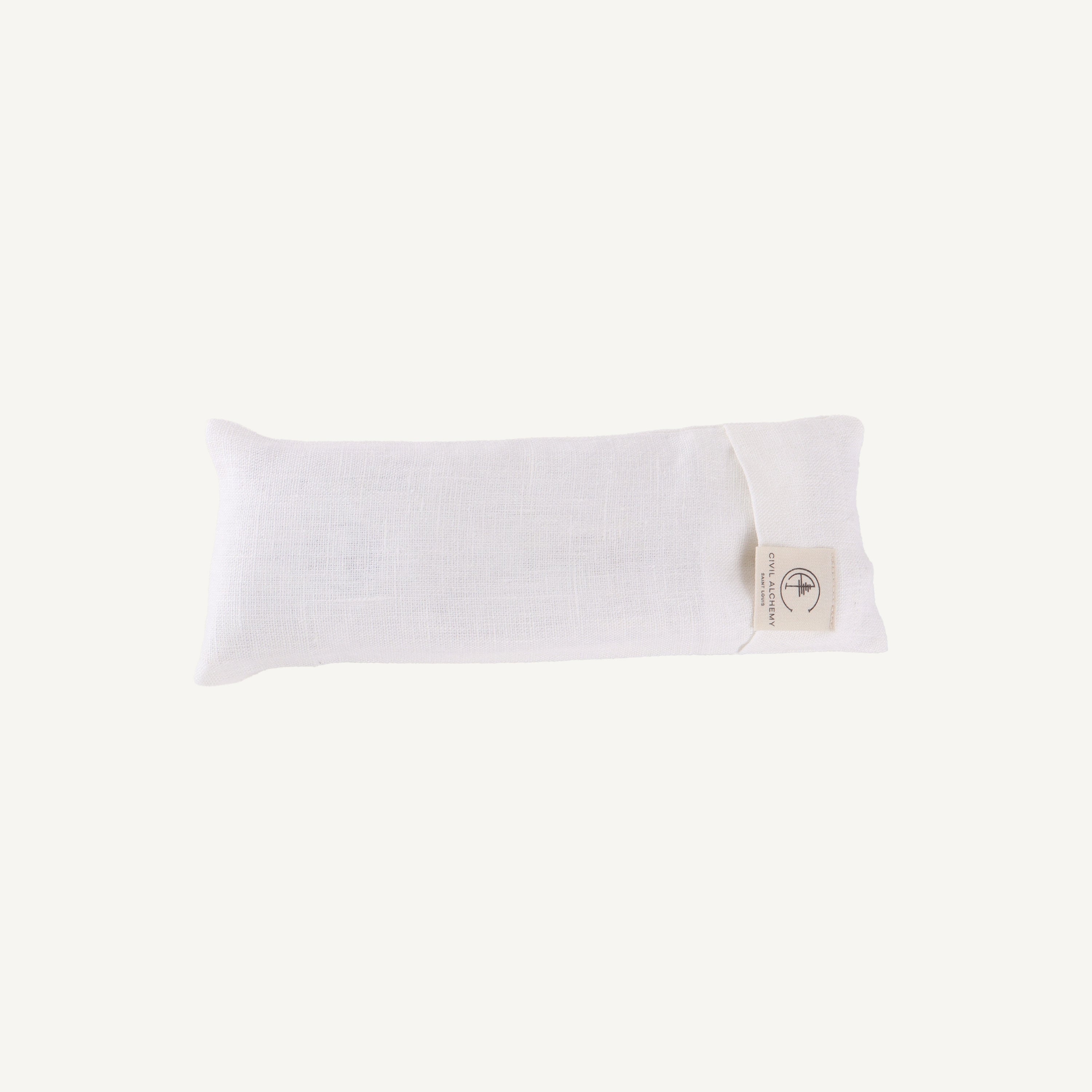 White pillow on a white background with a visible brand tag.