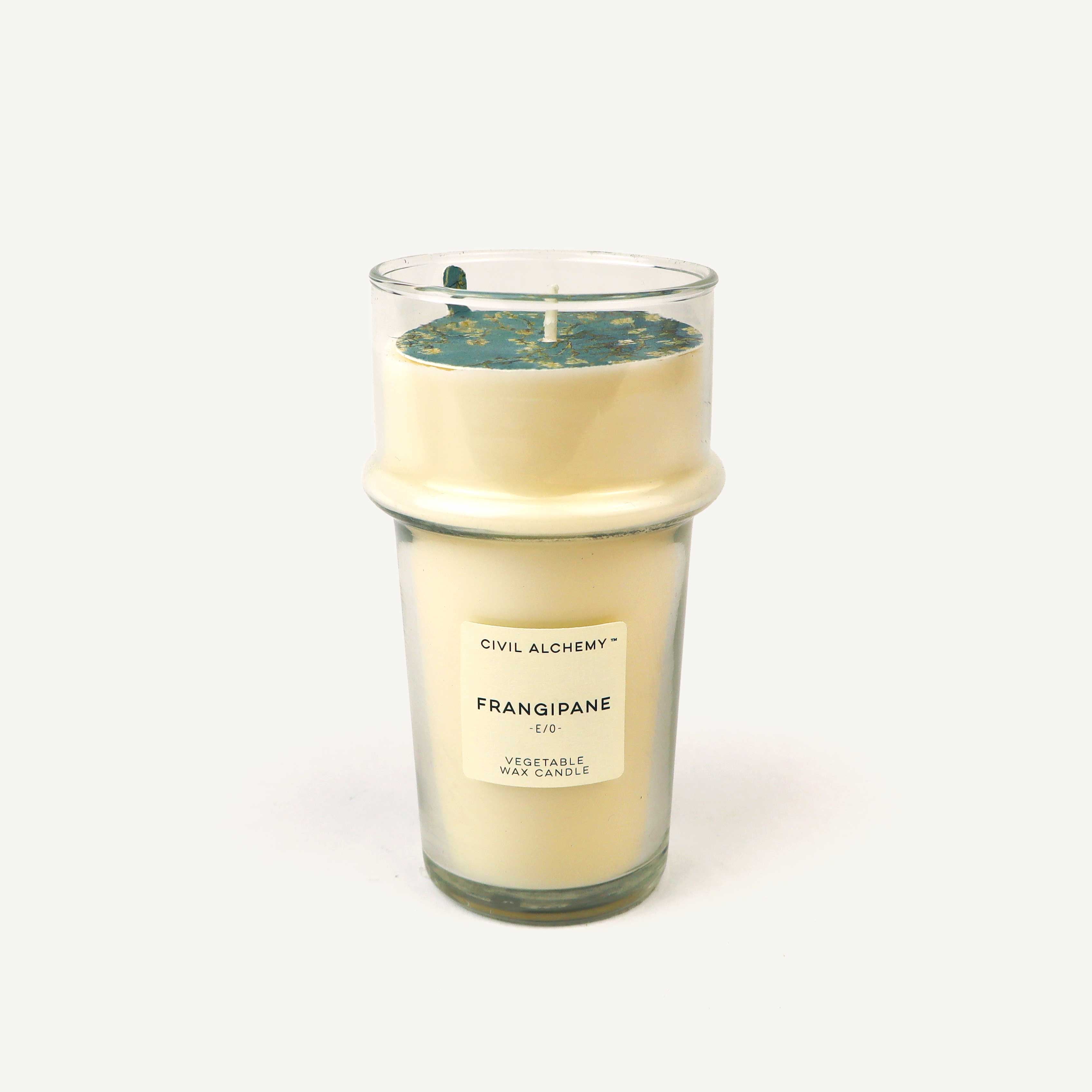Candle with visible "Frangipane" label on a white background