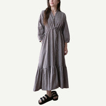 Load image into Gallery viewer, Woman wearing a black and white checkered dress on a plain background
