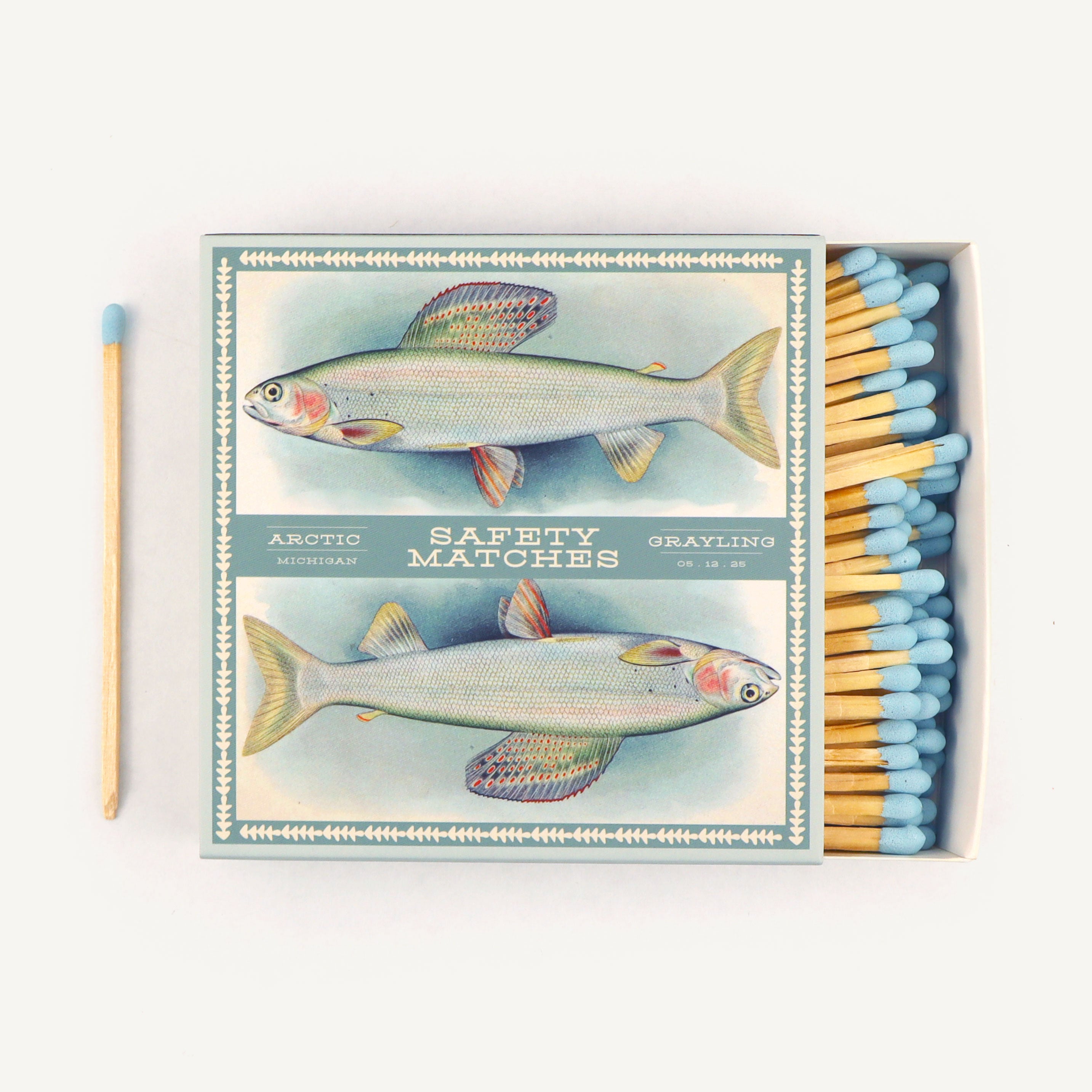 Matchbox with fish illustration and safety matches on a white background