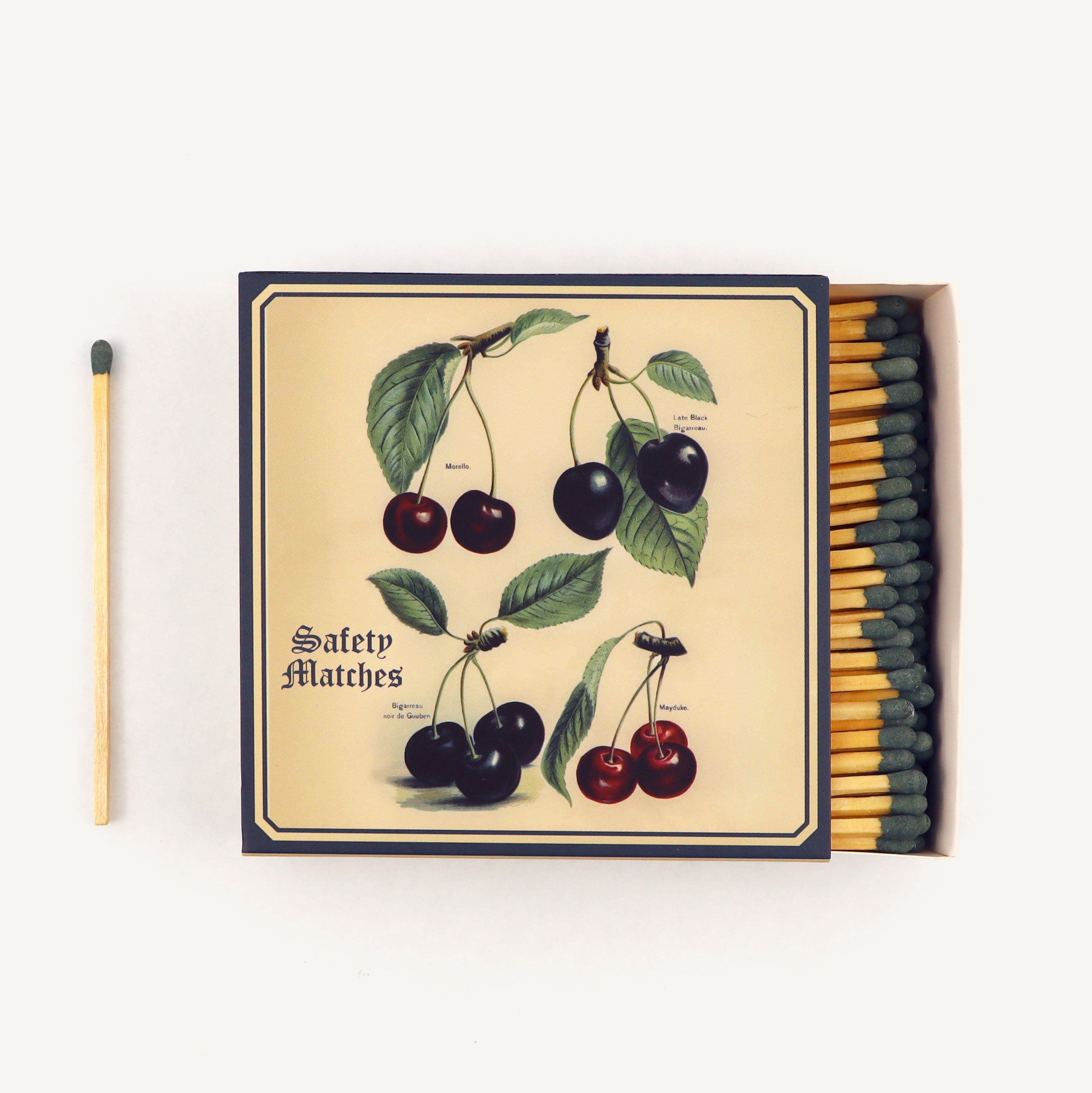 Matchbox with cherry design and safety matches on a white background
