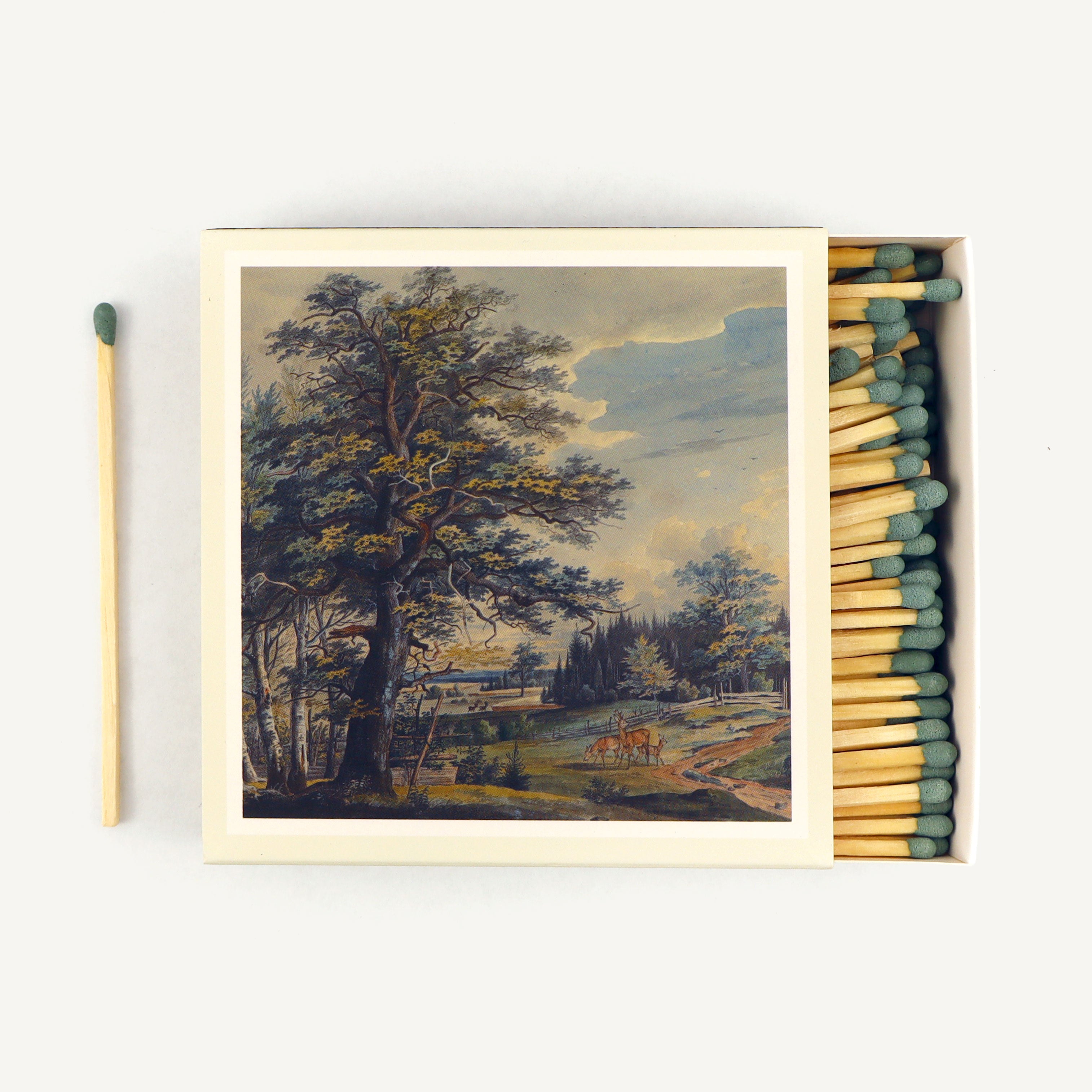 Matchbox with a scenic painting of a tree and landscape on a white background